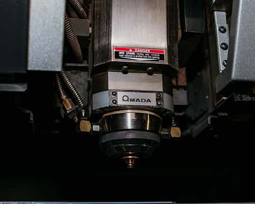 sparks flying as a machine uses laser to cut into a thick piece of metal